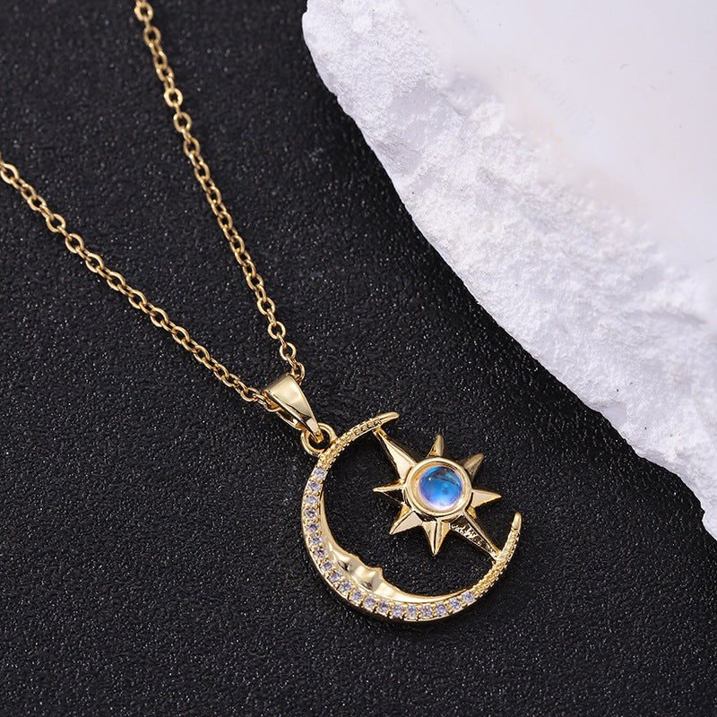 Gold necklace with moon and star pendant on a black and white background