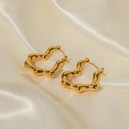 Gold hoop earrings on a beige satin background