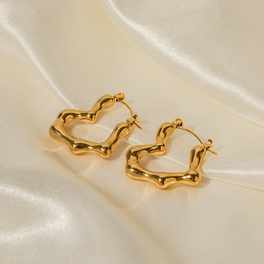 Gold hoop earrings on a beige satin background