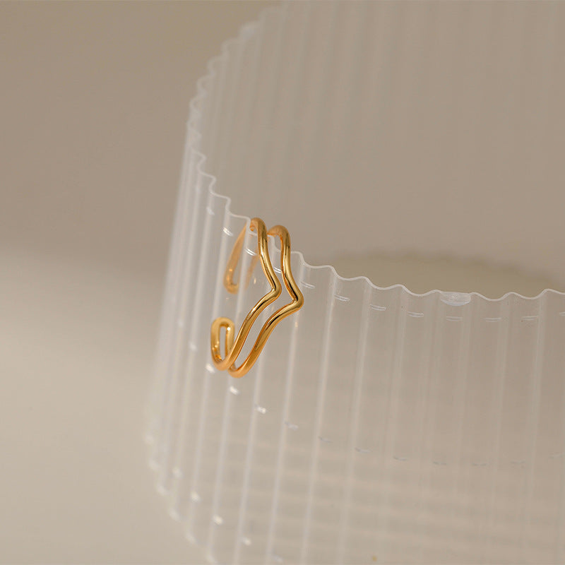 Gold hanger-shaped clip on a clear plastic container with a beige background