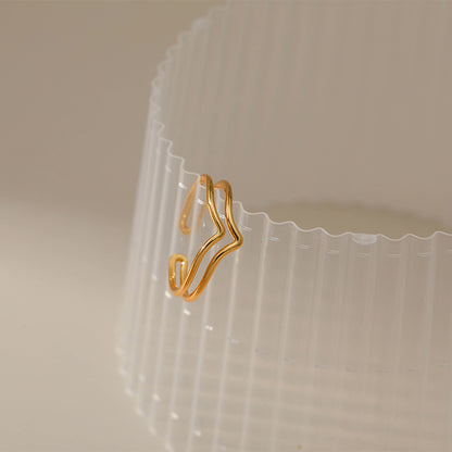 Gold hanger-shaped clip on a clear plastic container with a beige background