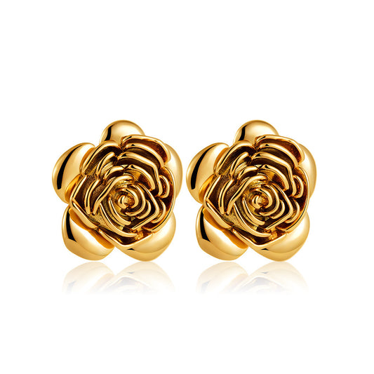 Gold rose-shaped earrings on a white background