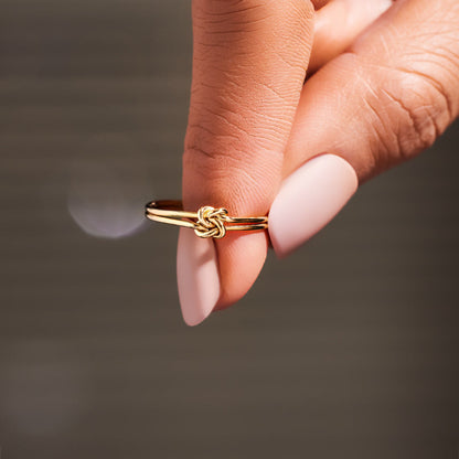 Gold floral ring with delicate petals, showcased flat on a crisp white background.