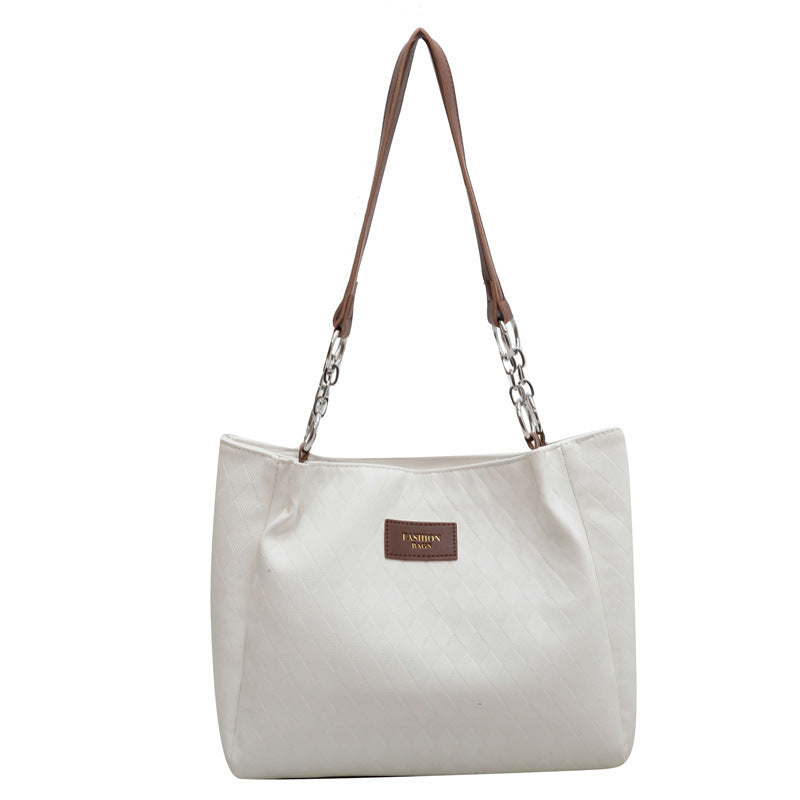 Cream and black rhombus pattern tote bag with chain shoulder strap and leather handle, ideal for shopping or everyday use.