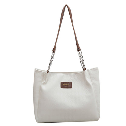Cream and black rhombus pattern tote bag with chain shoulder strap and leather handle, ideal for shopping or everyday use.