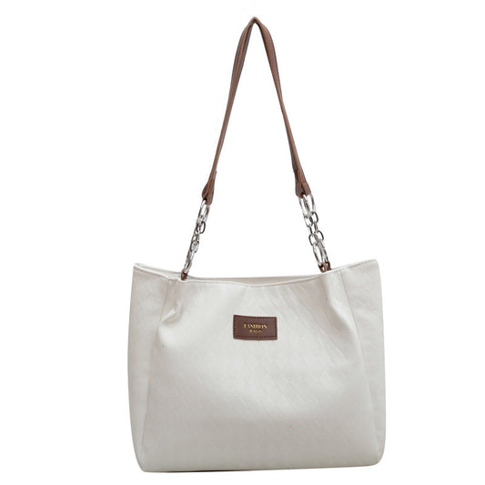 Cream and black rhombus pattern tote bag with chain shoulder strap and leather handle, ideal for shopping or everyday use.