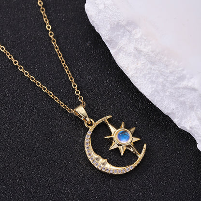 Gold necklace with moon and star pendant on a black and white background
