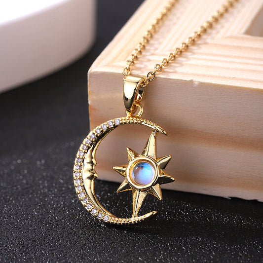 Gold necklace with moon and star pendant on a dark surface