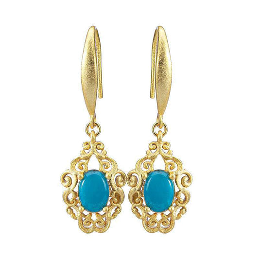Gold earrings with blue stones on a white background