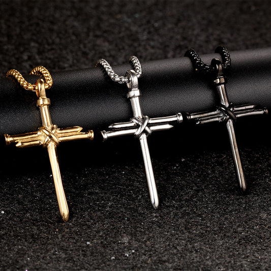 Three cross-shaped pendants in gold, silver, and bronze on a black background