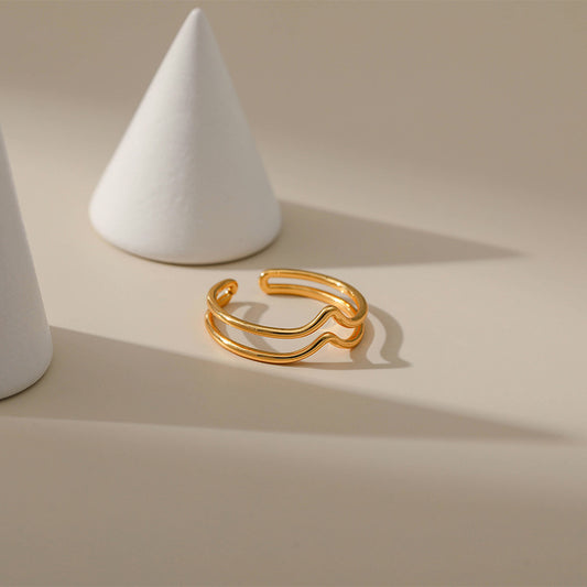 Gold ring on a beige surface with white conical objects