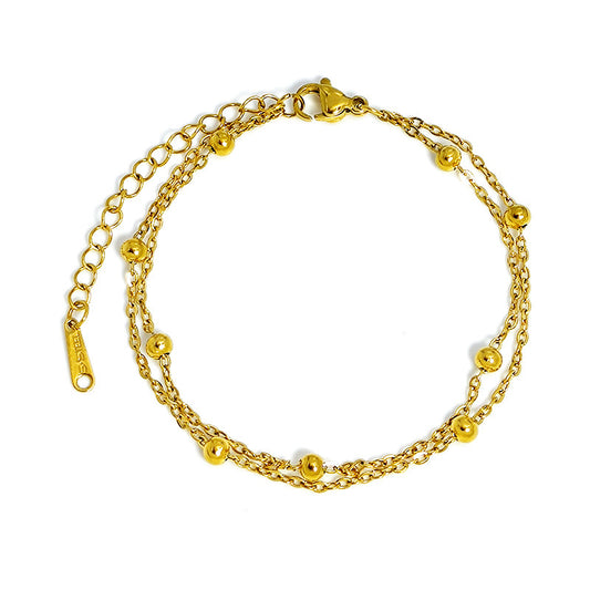 Gold double-chain bracelet with round beads, displayed flat on a clean white background